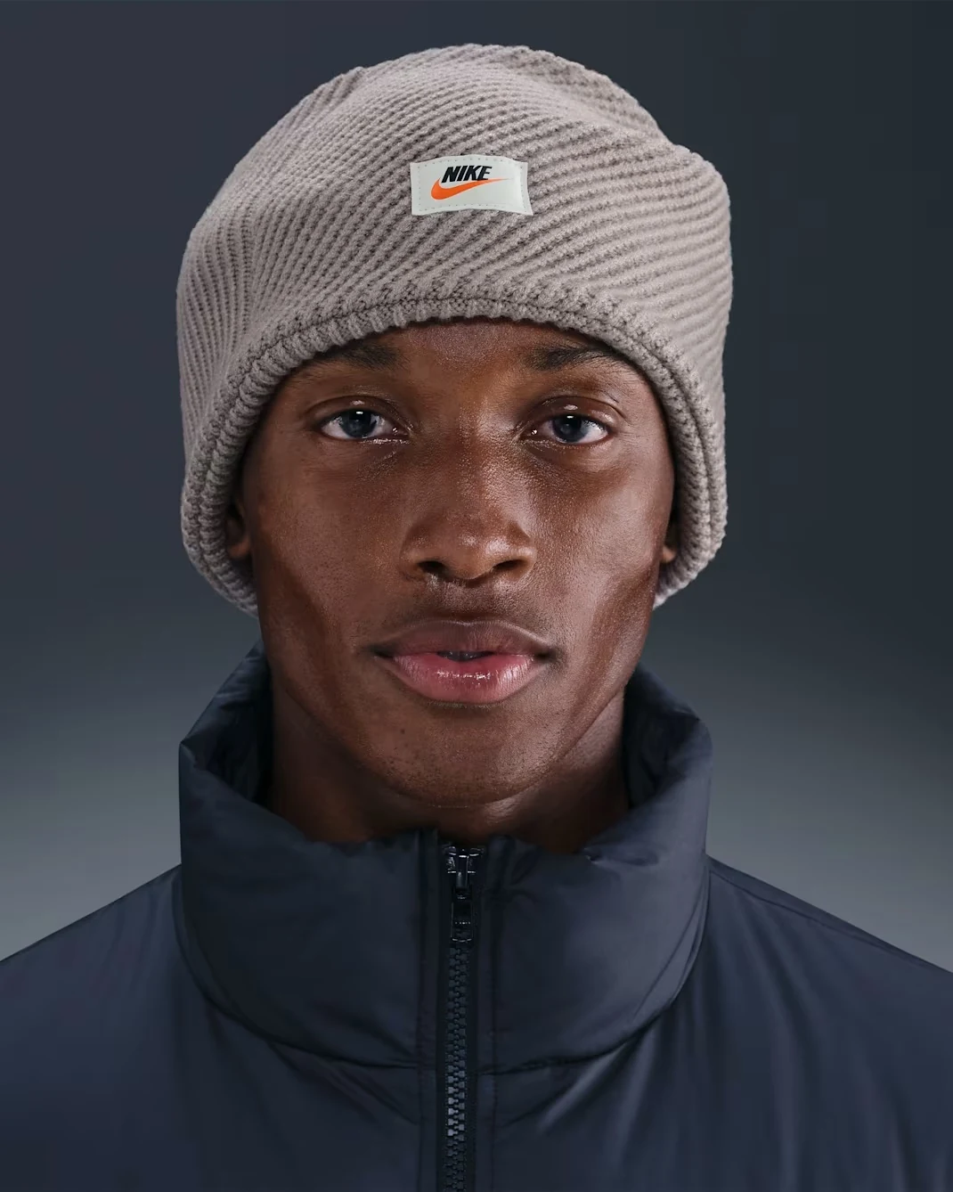 Nike City Knit headband in College Grey and Sail shown with ribbed knit texture and Nike label