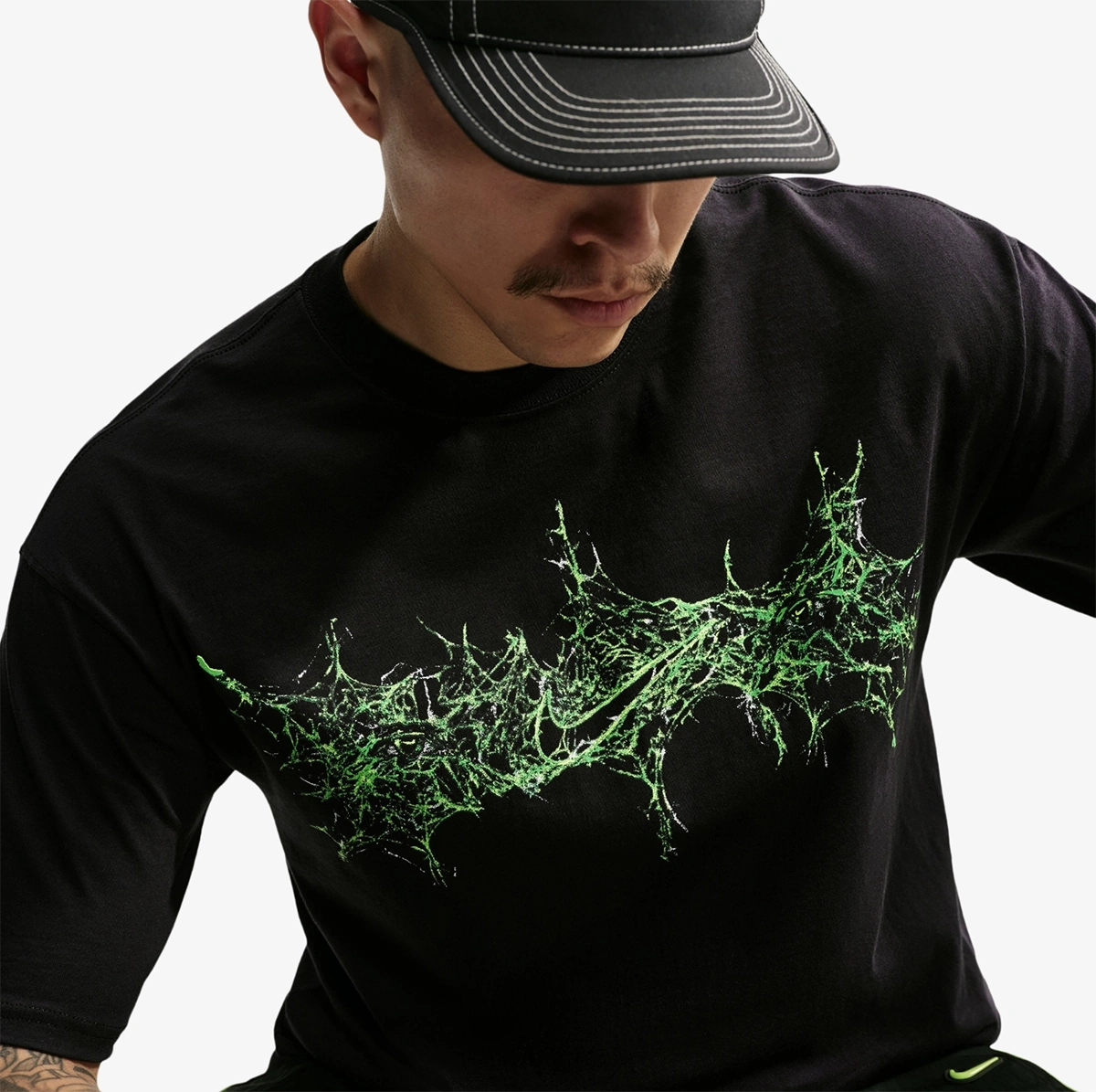 Close-up of the black Nike Halloween Max90 T-Shirt showing the green spiderweb-inspired Nike graphic across the front.