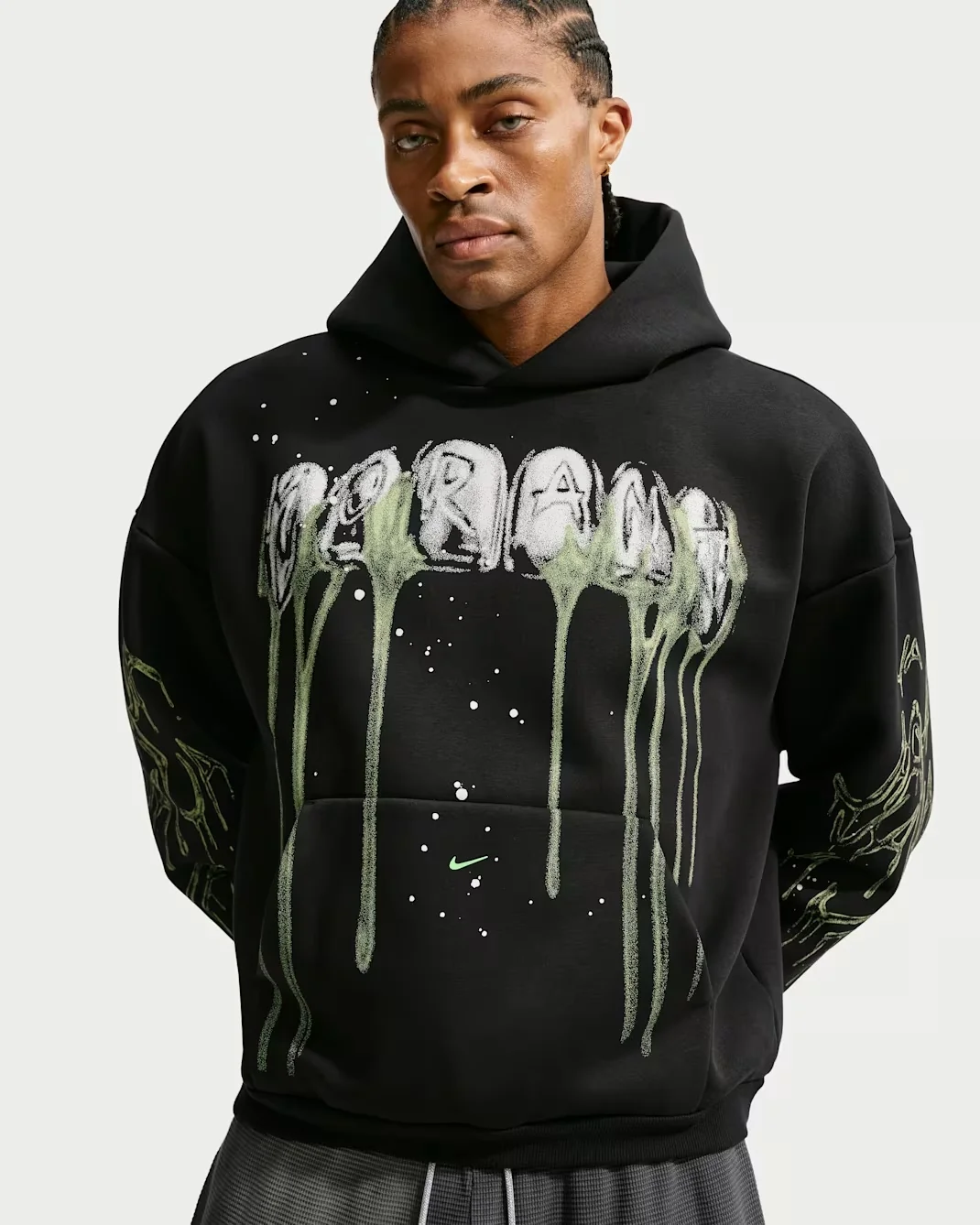 Model wearing the black Nike Ja Halloween hoodie with dripping green Scream lettering, skeleton graphics on the sleeves and green Nike Swoosh.
