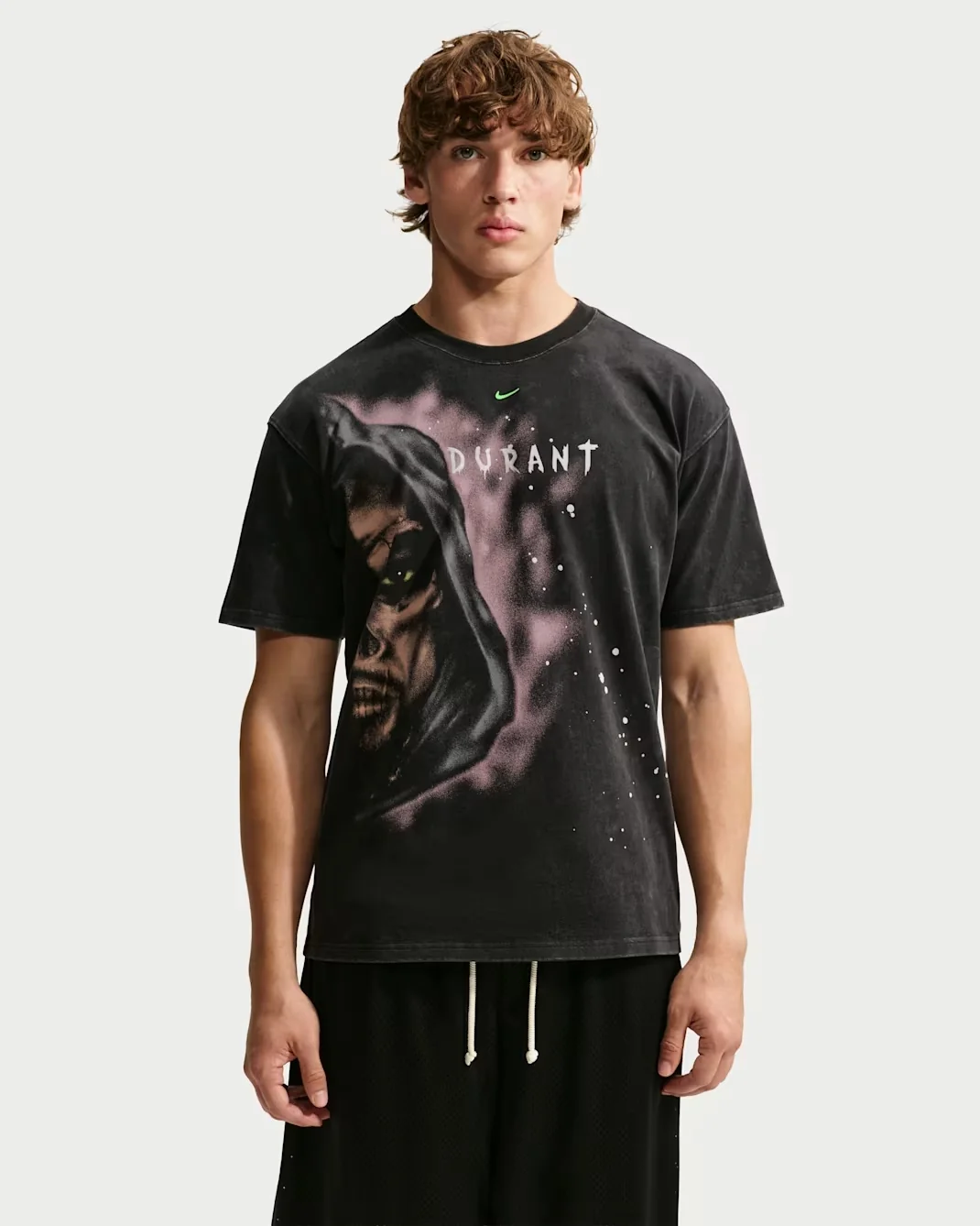 Model wearing the black Nike KD Halloween basketball T-shirt featuring a hooded Grim Reaper portrait, purple background graphics and Durant lettering.