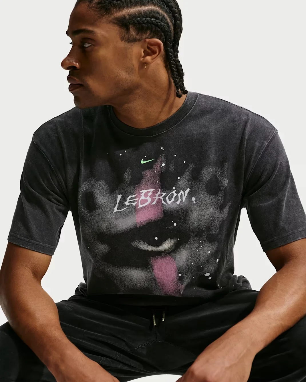 Model wearing the black Nike LeBron Halloween basketball T-shirt with a grey face graphic, purple accents and white LeBron lettering.