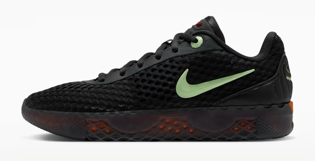 Side view of the Nike LeBron Witness X Halloween basketball shoe in black and dark smoke grey with pale green Swoosh and orange accents.
