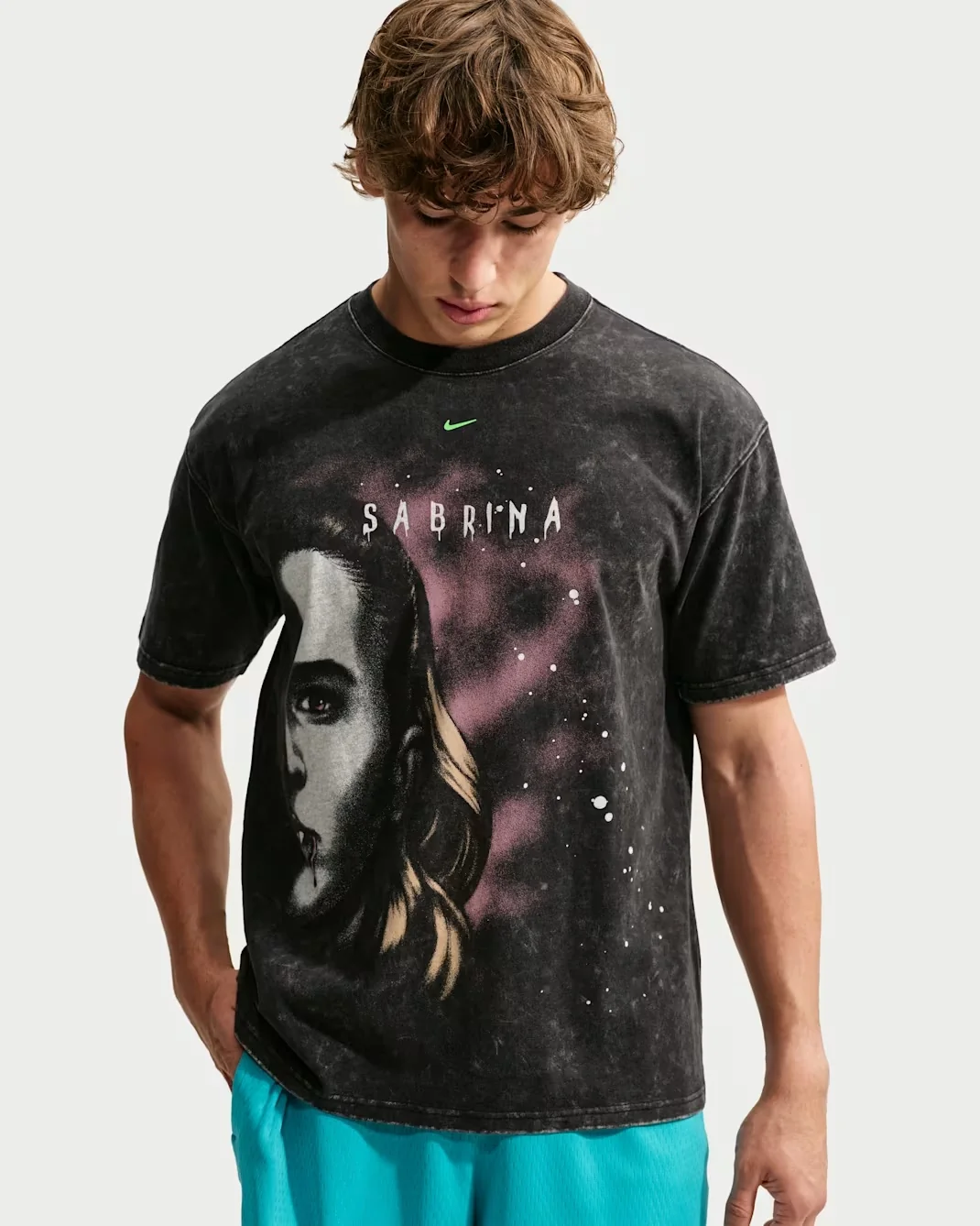 Model wearing the black Nike Sabrina Halloween basketball T-shirt with a vampire-inspired portrait, purple background graphics and Sabrina lettering.