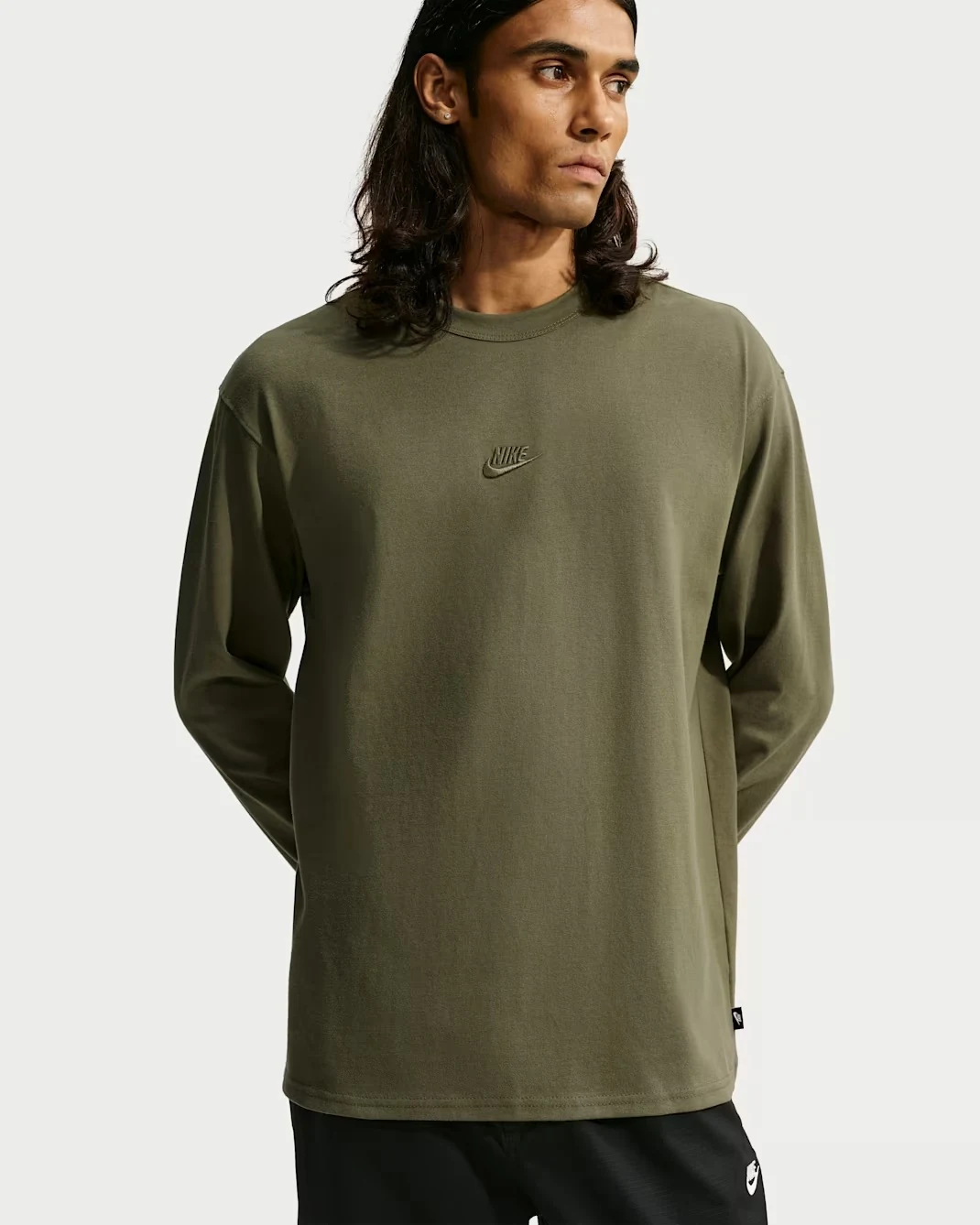 Nike Sportswear Premium Essentials Long-Sleeve T-Shirt in Medium Olive featuring a relaxed fit and embroidered Nike Futura logo on the chest.