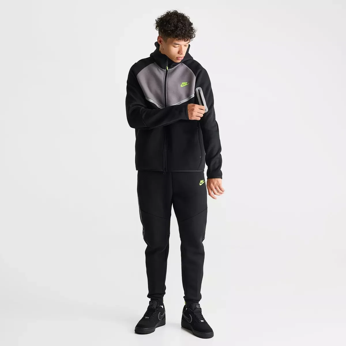 Nike Tech Fleece Reflective Windrunner Full-Zip Hoodie and matching jogger pants in Black, Flat Pewter and Volt worn as a complete outfit with Nike Air Force 1 sneakers.