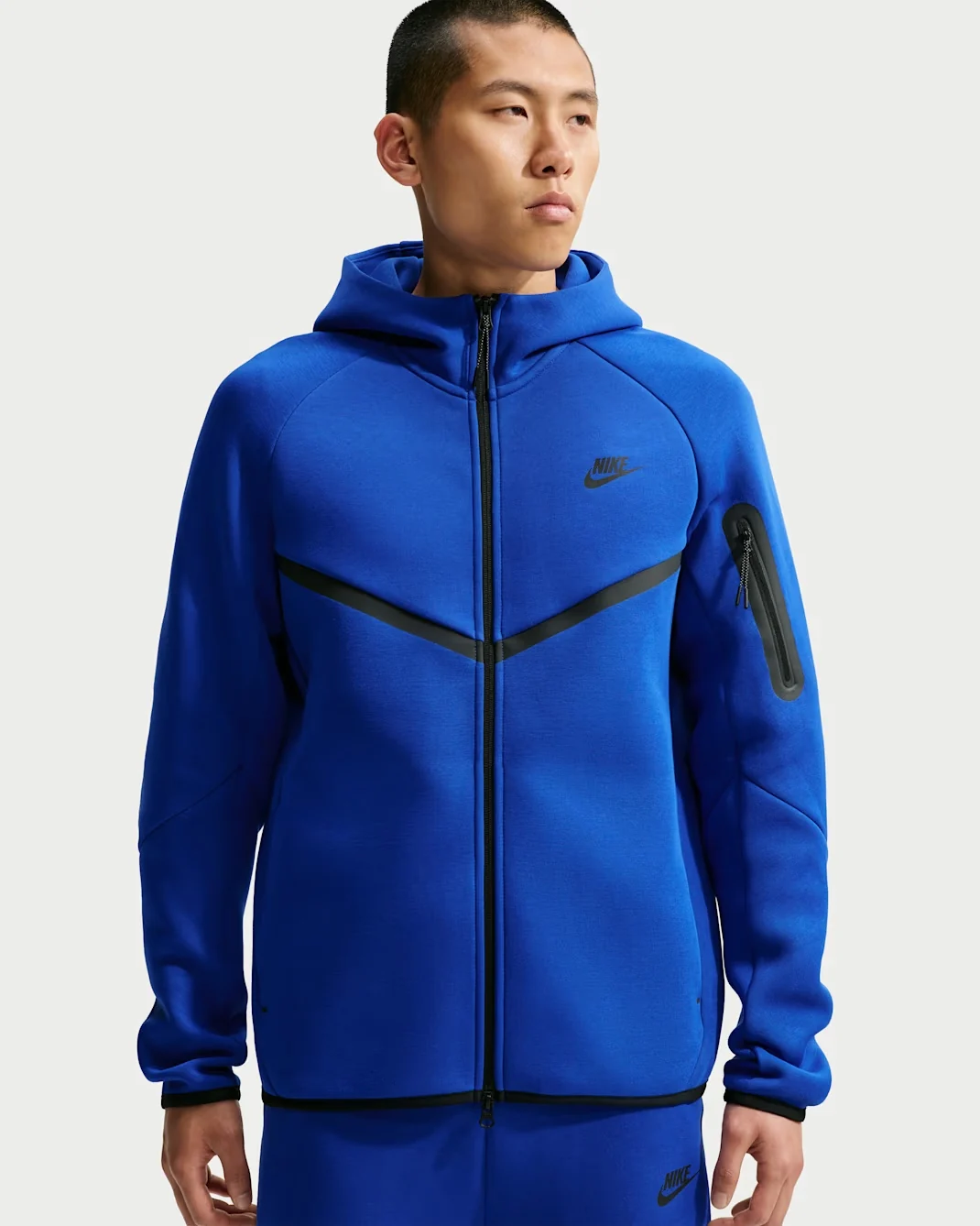 Royal blue Nike Tech Fleece Windrunner full-zip hoodie with black chevron detailing and sleeve zipper pocket